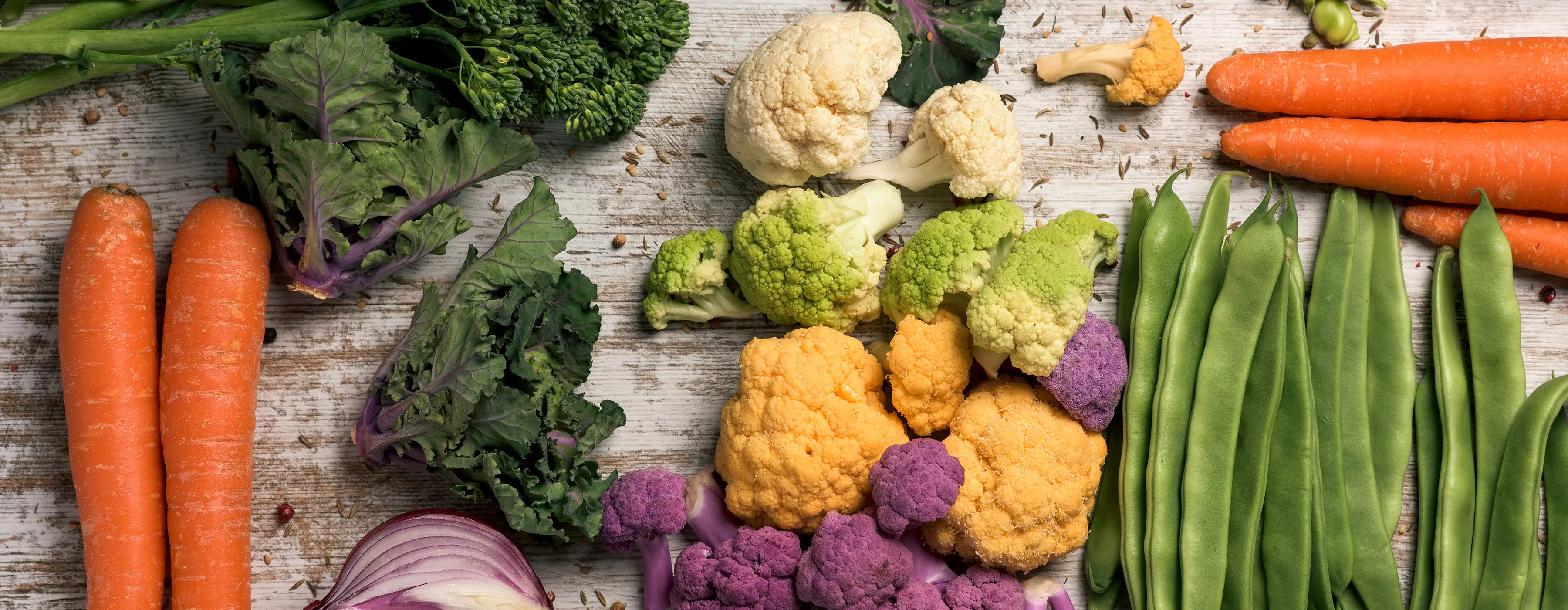 Foto em close de verduras e legumes em cima de uma bancada