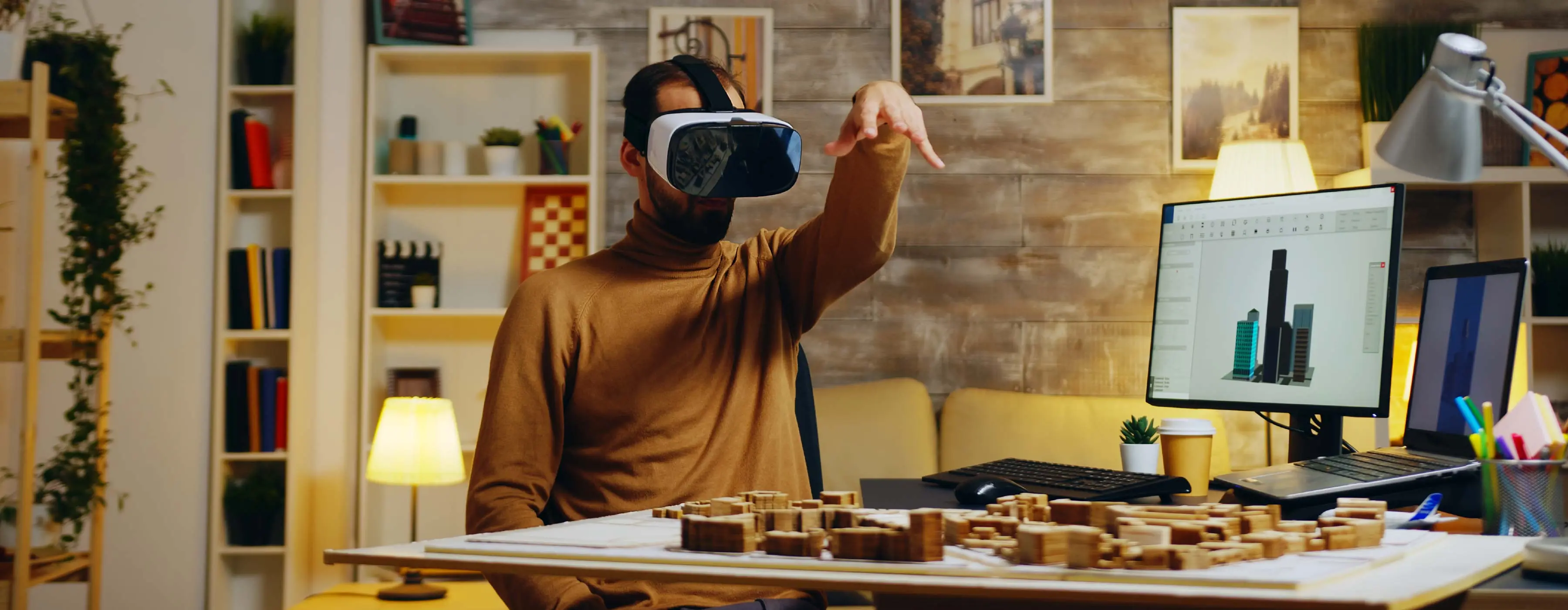 Foto de homem utilizando óculos de realidade virtual em um cenário de livros, computador e peças em cima da mesa.