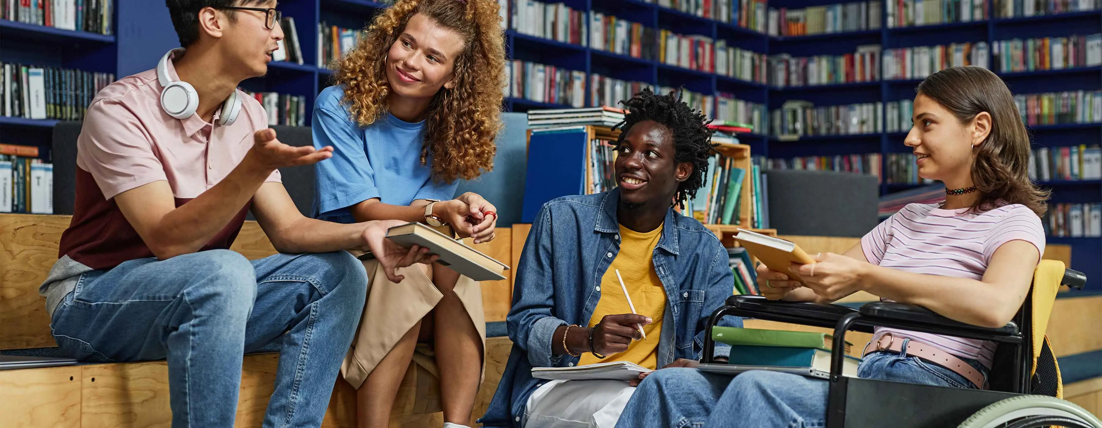 Foto de um grupo de pessoas estudando na biblioteca.