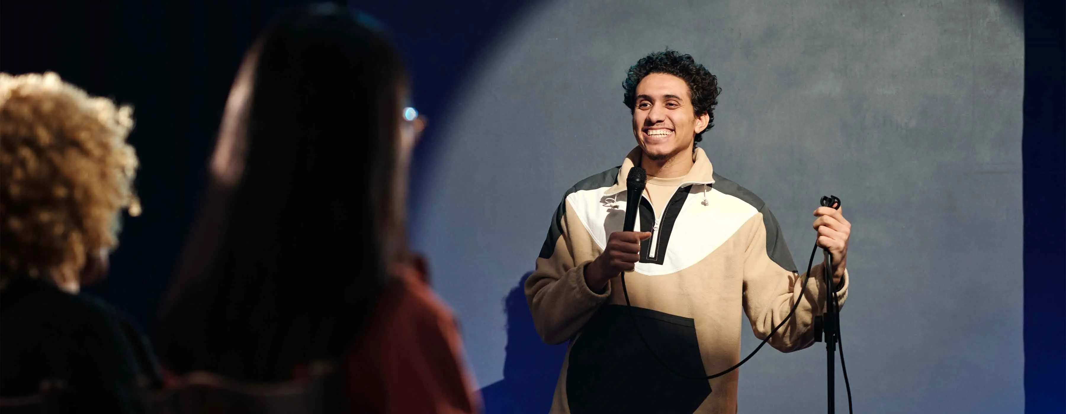 Foto de um homem em um palco segurando um microfone.