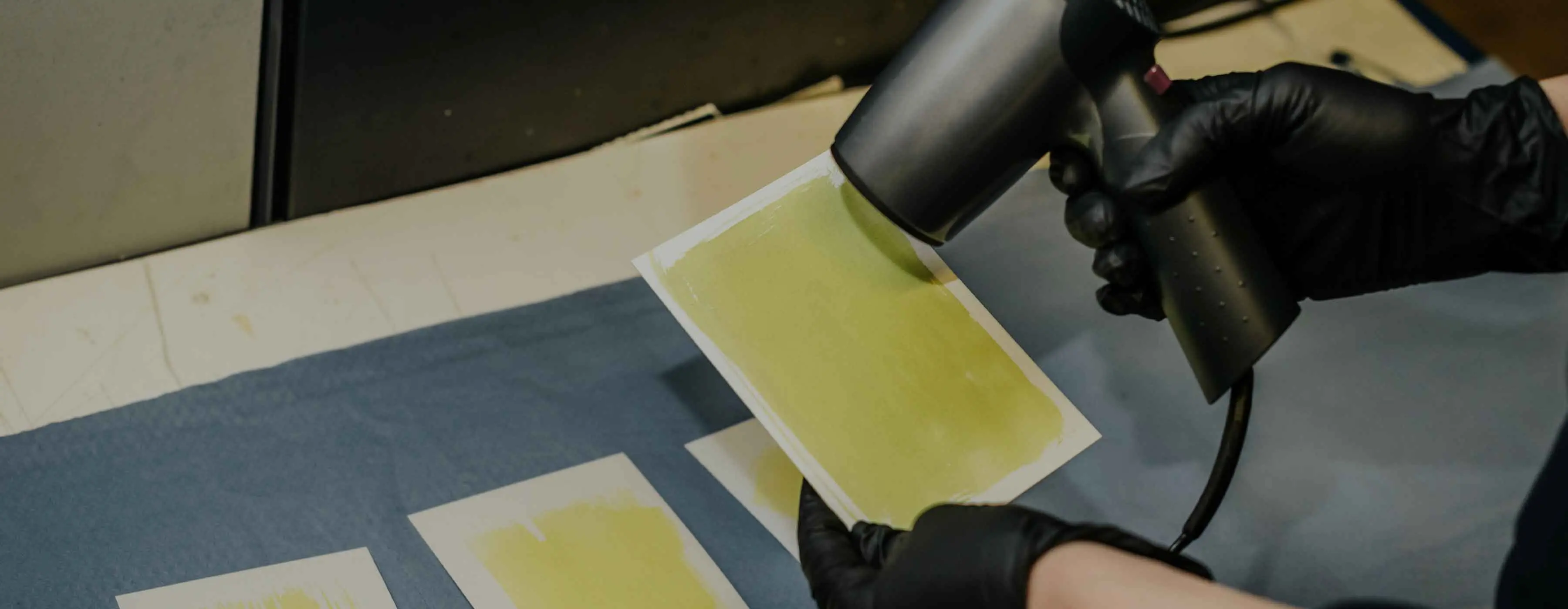 Foto de uma pessoa secando uma folha de papel pintada com tinta.