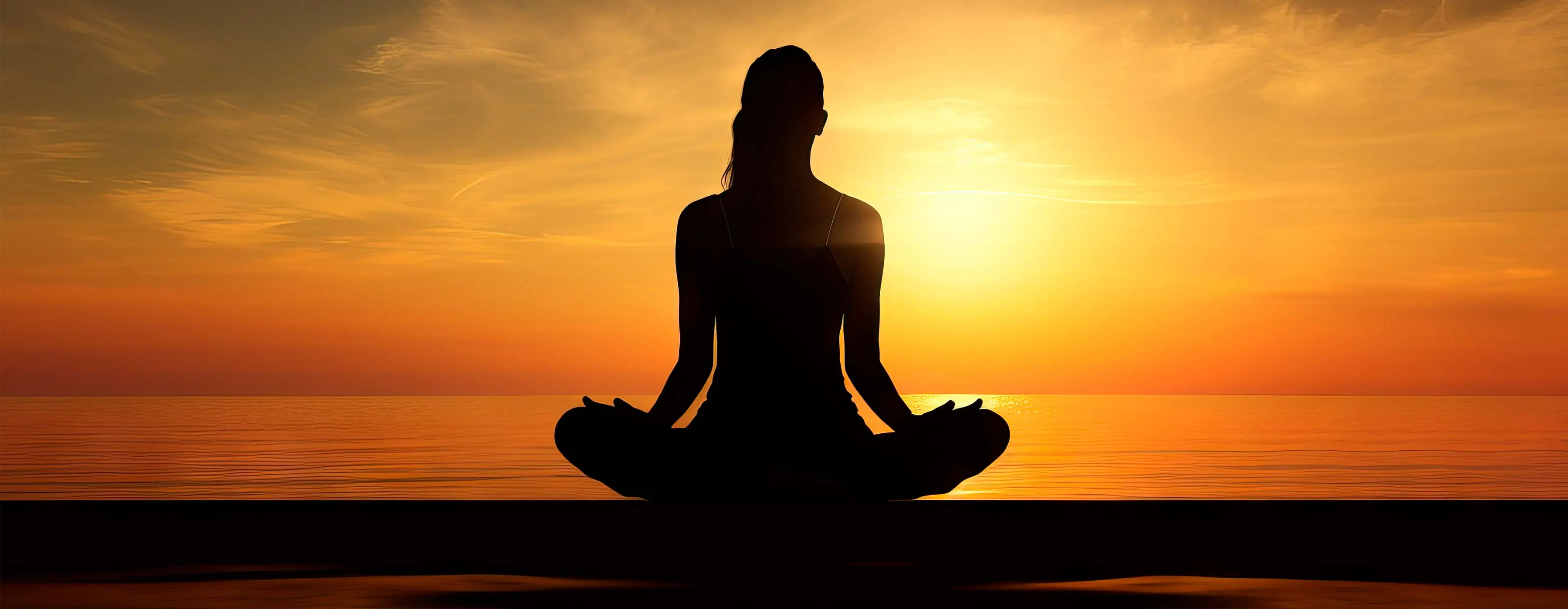 Foto de uma mulher sentada no chão em posição de meditação