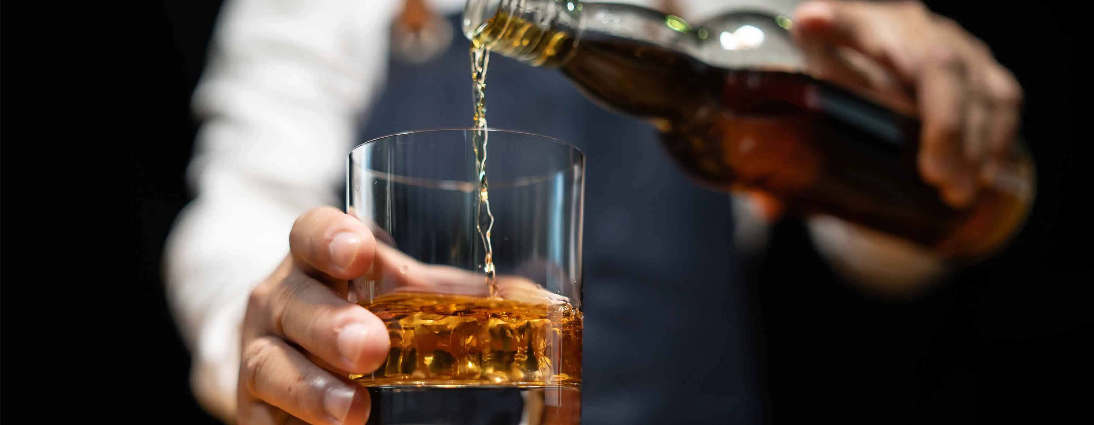 Foto de uma pessoa servindo whisky