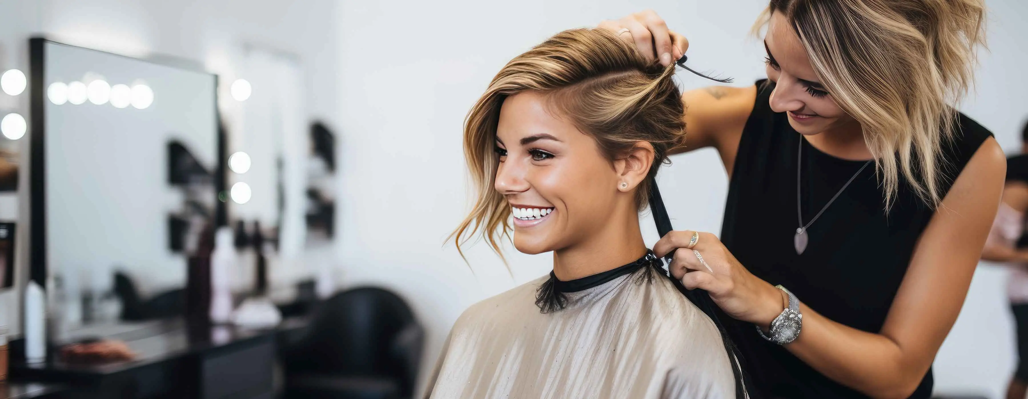 Foto de uma profissional em um salão de beleza, cortando o cabelo de uma moça.