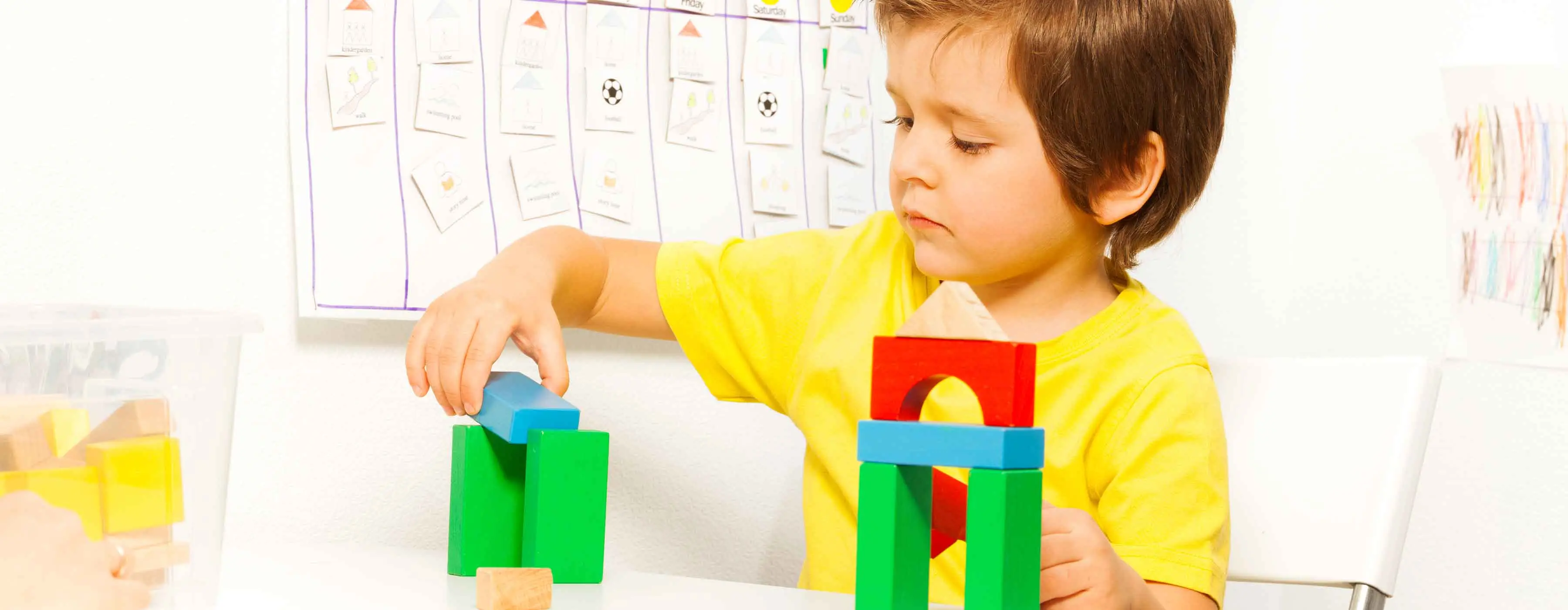 Criança brincando com blocos de construir. 