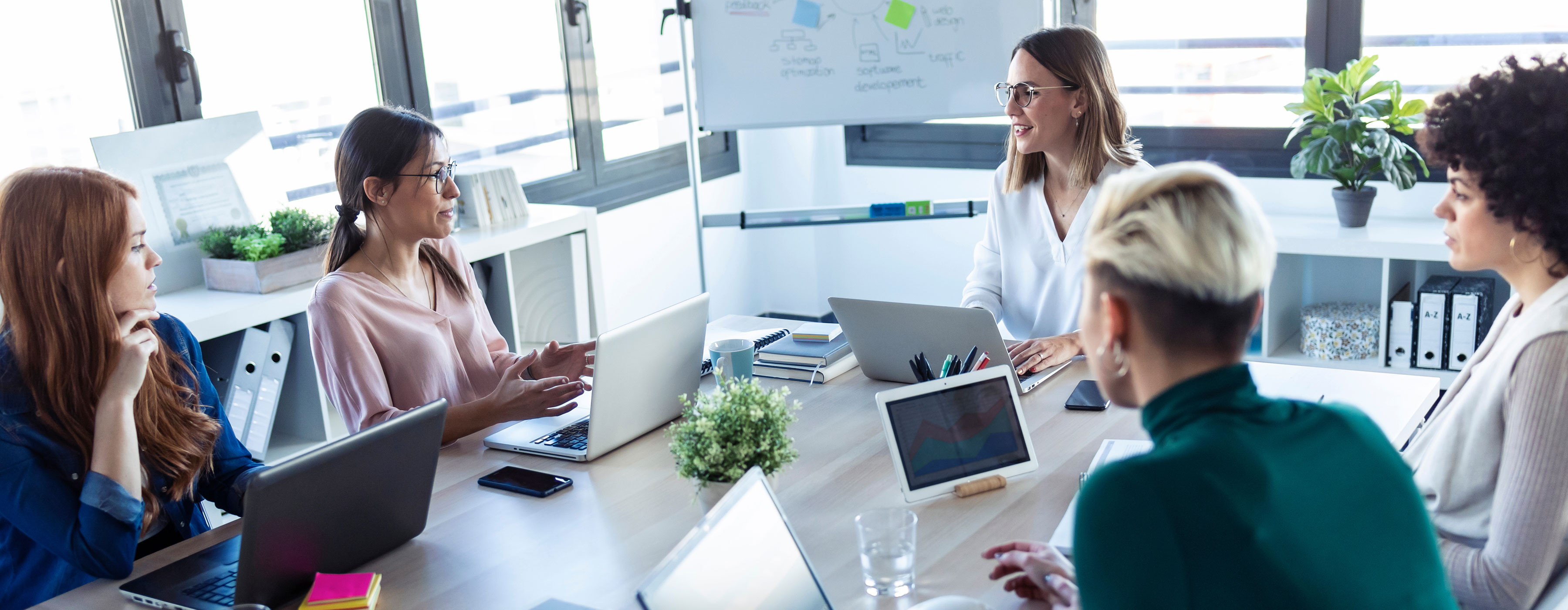 Atitude Empreendedora: utilizando as ferramentas ikigai, golden circle e business model canvas - foto de uma sala de reunião, com mulheres sentadas ao redor de uma mesa usando notebooks.
