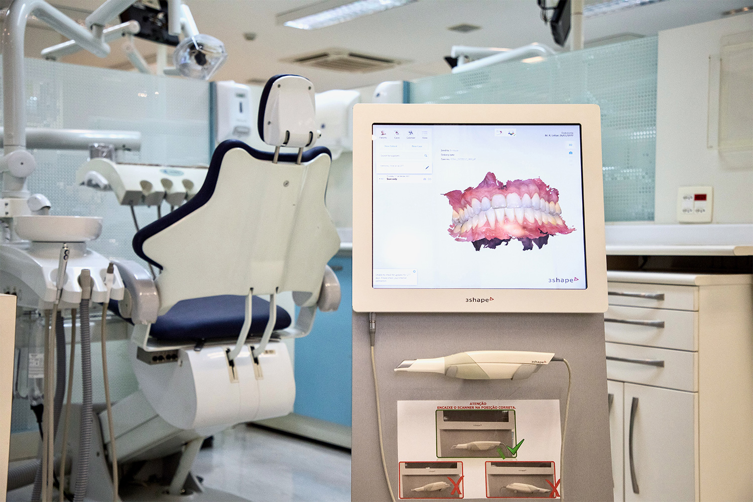 Foto de equipamentos da clínica odontológica, com cadeira, ferramentas e scanner intraoral.
