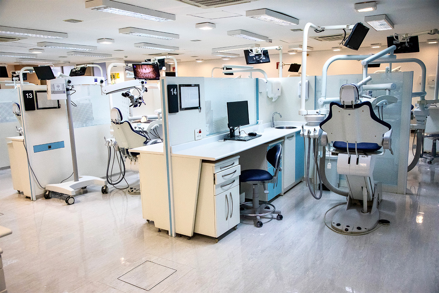 Foto geral da clínica odontológica do Senac Tiradentes, com equipamentos, cadeiras e monitores aparentes.