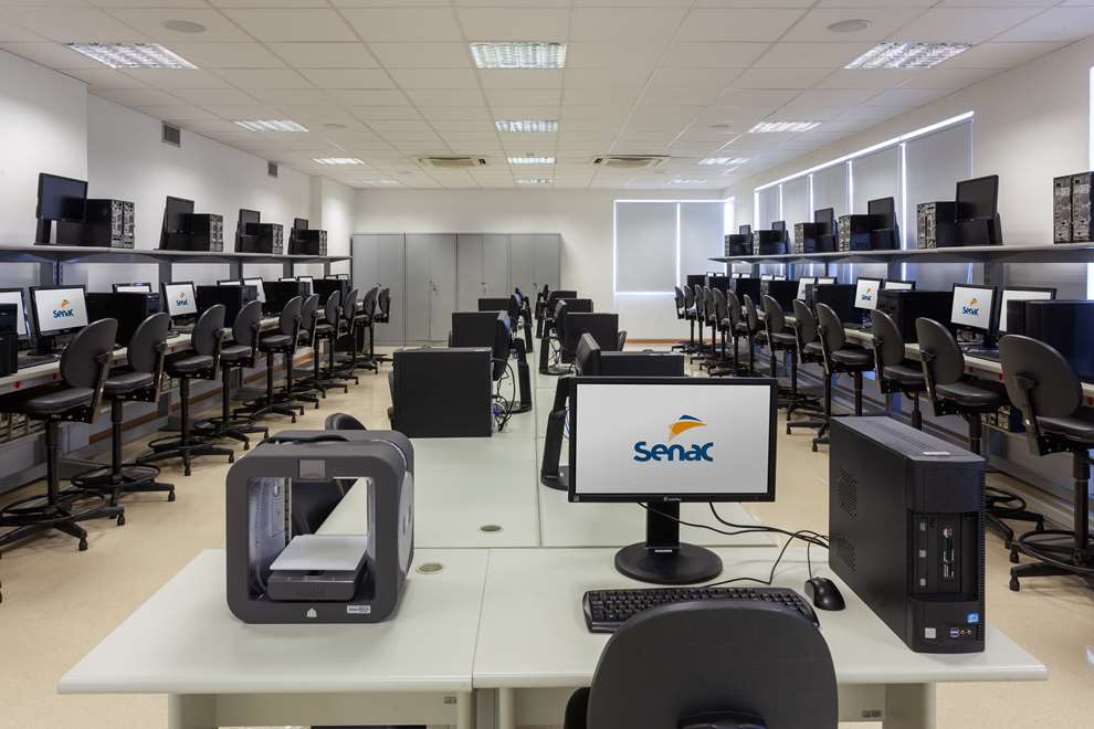 sala com bancadas , cadeiras altas e computadores.