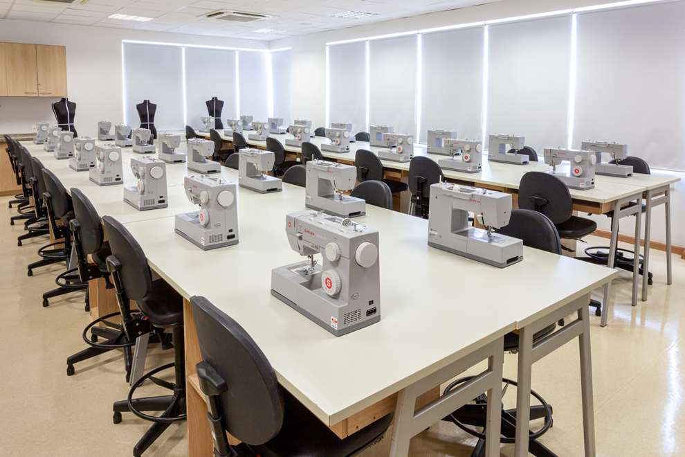 sala com dois manequins de moda e máquina de costura