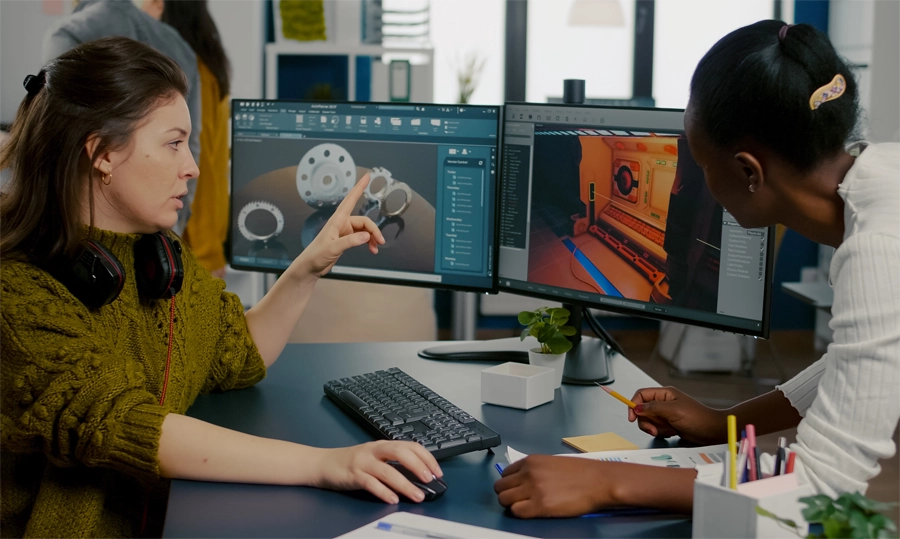 Imagem: duas técnicas em programação de jogos digitais conversam sobre o desenvolvimento de um jogo no qual estão trabalhando juntas.