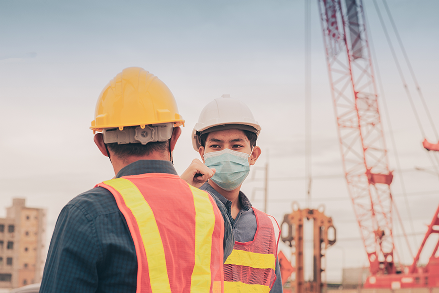 Dois trabalhadores utilizando equipamentos de EPI na construção civil.
