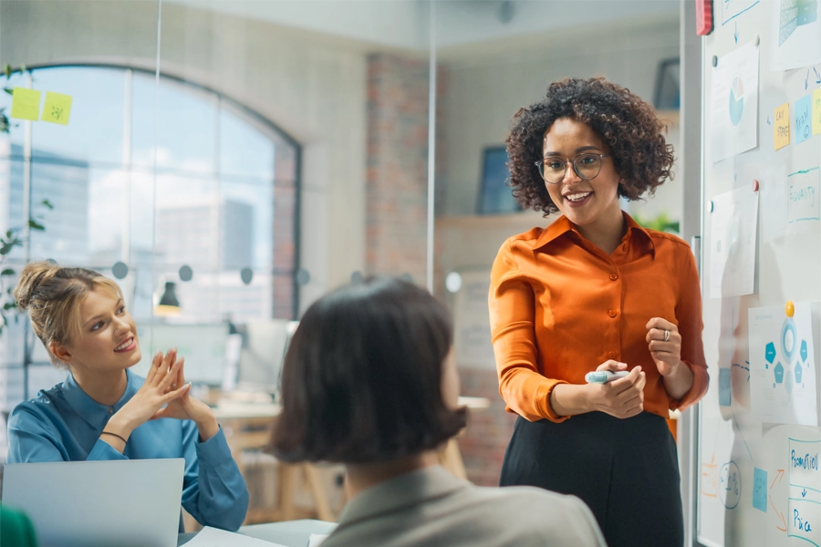 Imagem: uma técnica em marketing conversa com seu time em uma reunião estratégica de trabalho.