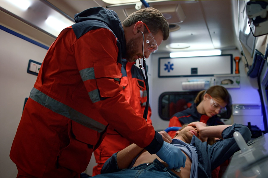 Imagem: enfermeiro especialista em urgência e emergência presta os primeiros socorros a um homem, vítima de acidente, que é transportado em ambulância.
