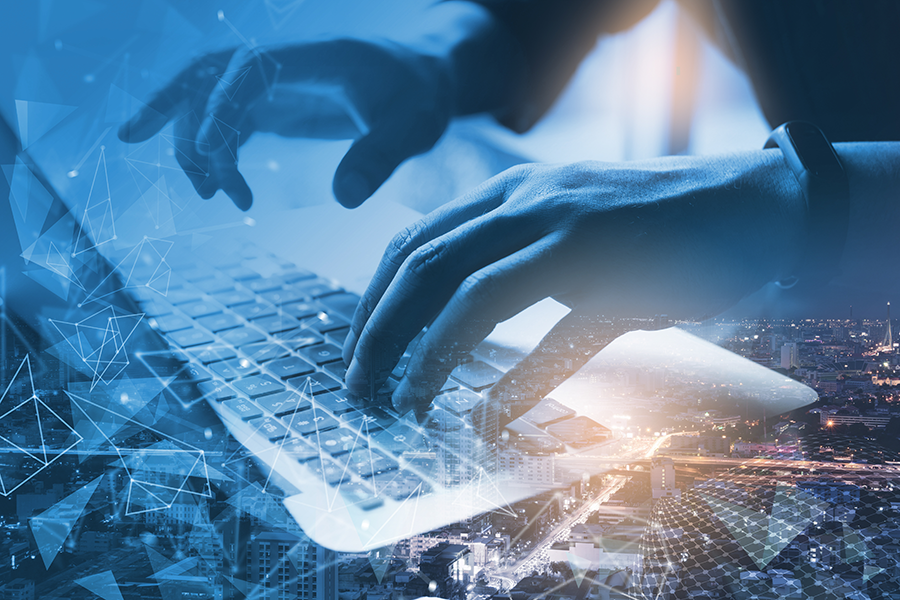 No segundo plano, mãos digitando em um teclado com imagens relacionadas a sistemas de informação no plano principal