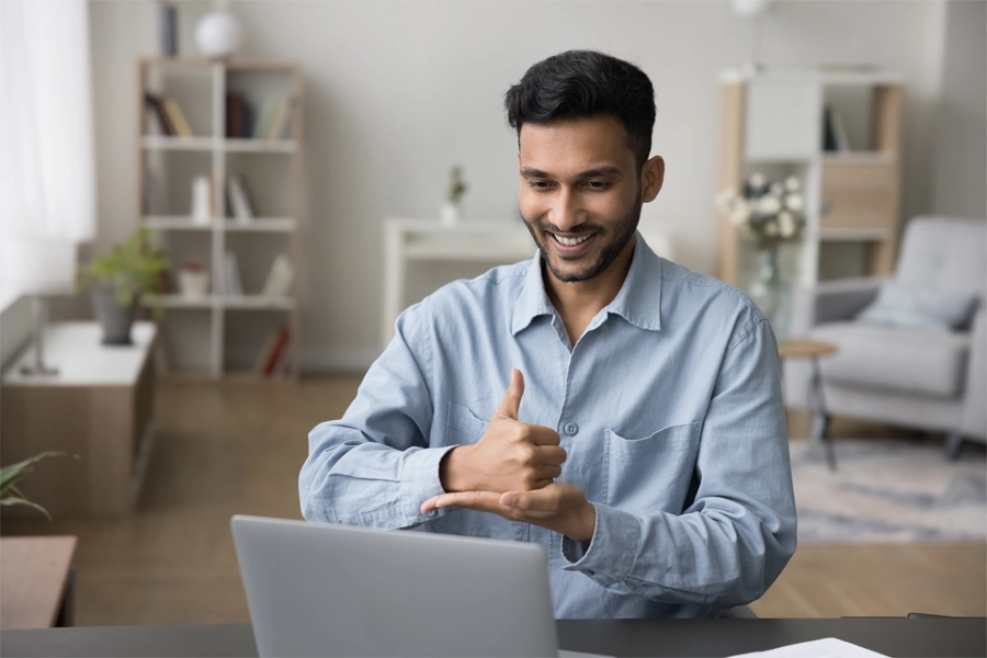 Imagem: um homem utiliza Libras para se comunicar em uma reunião de trabalho. 