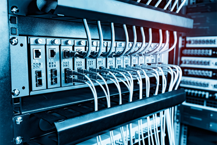 Imagem: parede com diversos cabeamentos de redes de computadores.