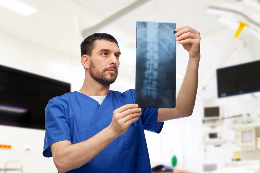 Imagem: Radiologista analisando a chapa de um exame contraluz. 