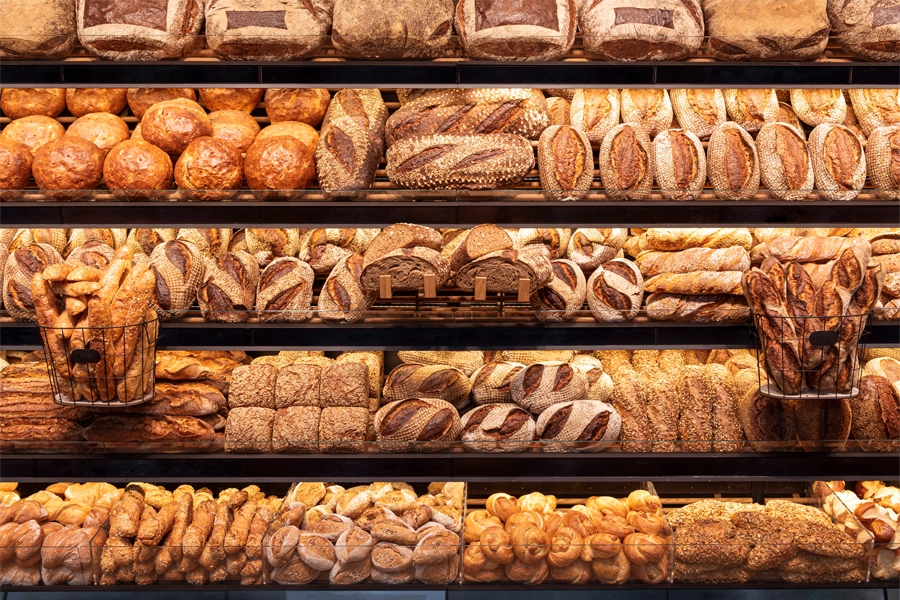 Imagem: vitrine de padaria com diferentes tipos de pães especiais.