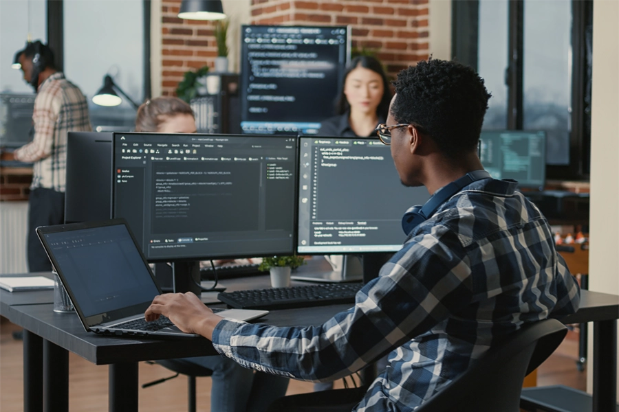 Imagem: técnico em desenvolvimento de sistemas programando em escritório.