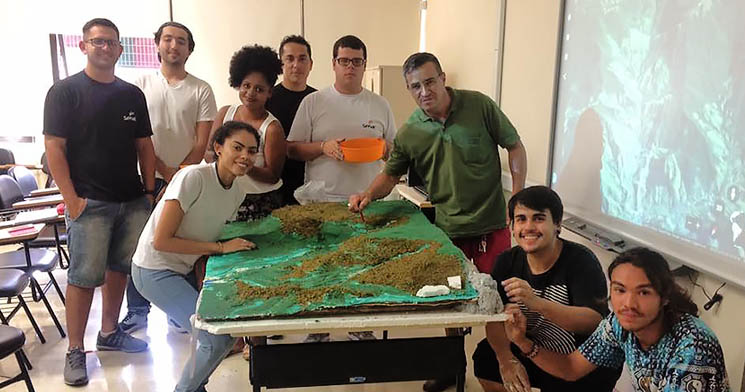 Alunos do curso Técnico em Meio Ambiente do Senac Guaratinguetá sorridentes ao lado da maquete das Serra da Mantiqueira Alunos do curso Técnico em Meio Ambiente do Senac Guaratinguetá sorridentes ao lado da maquete das Serra da Mantiqueira