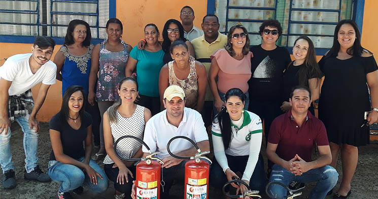 Turma reunida lado a lado com extintores apoiados no chão Turma reunida lado a lado com extintores apoiados no chão