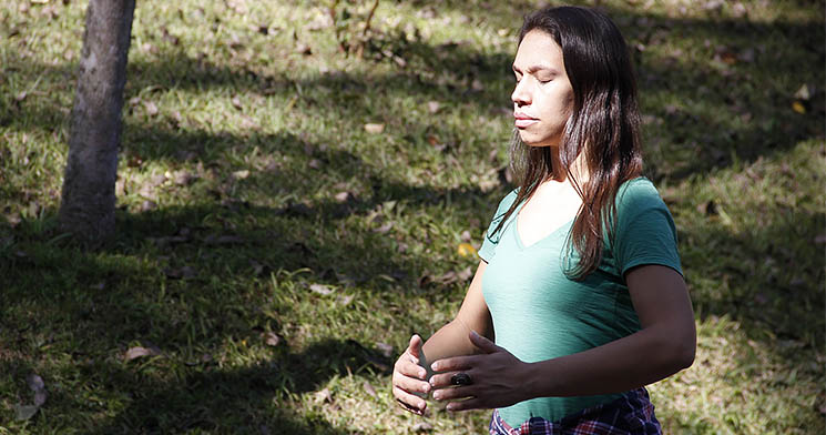 Mulher pratica Qi Gong em área arborizada Mulher pratica Qi Gong em área arborizada