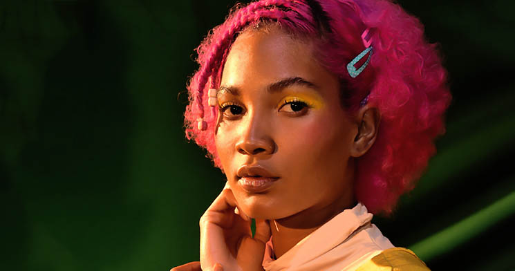 Jovem negra com cabelo curto rosa e maquiagem em tons de amarelo Jovem negra com cabelo curto rosa e maquiagem em tons de amarelo