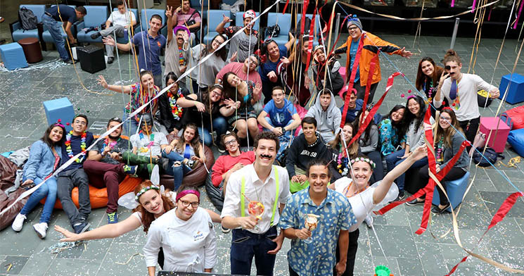 Jovens fantasiados em ambiente com decoração carnavalesca Jovens fantasiados em ambiente com decoração carnavalesca