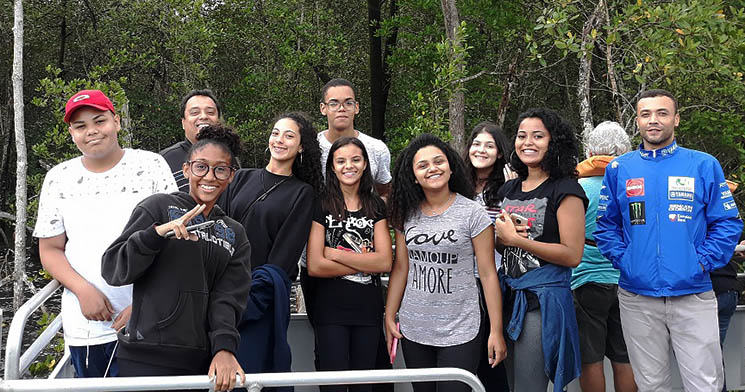 Alunos do Senac Bertioga em barco com árvores ao fundo Alunos do Senac Bertioga em barco com árvores ao fundo