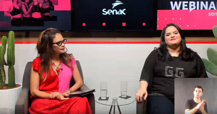Duas mulheres sentadas em estúdio e ao fundo tela escrito Webinar Senac. Duas mulheres sentadas em estúdio e ao fundo tela escrito Webinar Senac.
